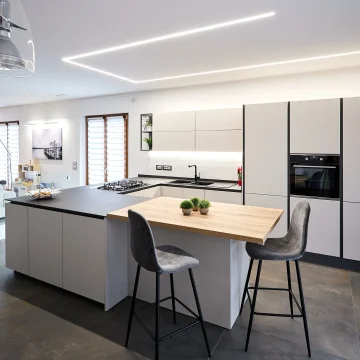 Immagine di una cucina moderna realizzata da Danilo Arredamenti con mobili grigio chiaro e tavolo attaccato all'isola